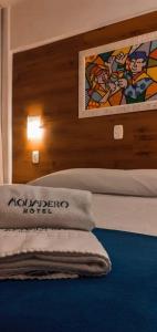 a bedroom with two beds and a painting on the wall at Hotel Aguadero in Passo Fundo
