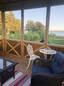 a screened in porch with two chairs and a table at Bluewaters Retreat Bachelor Unit in Vernon Bridge