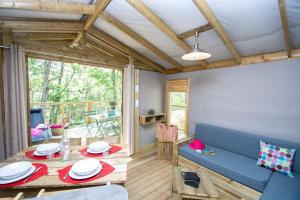 ein Wohnzimmer mit einem blauen Sofa und einem Tisch in der Unterkunft Camping les Restanques in Bauduen