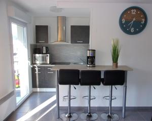 a kitchen with a counter and a clock on the wall at T2 50m2 entièrement neuf in Lourdes