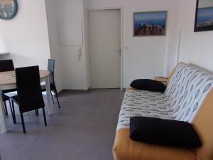 Cette chambre comprend un canapé, une table et un bureau. dans l'établissement T2 50m2 entièrement neuf, à Lourdes