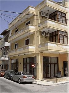 a building with two cars parked in front of it at Constantinos Studios in Chania