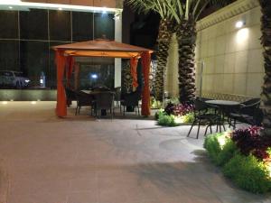 a gazebo with tables and chairs in a building at Mandarin Hotel Apartments in Riyadh