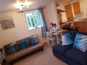 a living room with two couches and a table in a kitchen at Vetrelax Basildon Crosse Apartment in Basildon