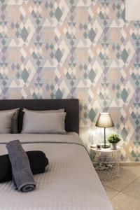 a bedroom with a bed and a geometric wallpaper at Thess home Now Luxury Apartment in Thessaloniki