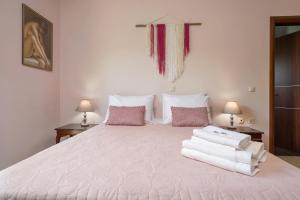 a bedroom with a large white bed with towels on it at Villa Serenity in Agia Marina