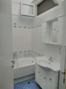 a white bathroom with a tub and a sink at Stavroula in Melissátika