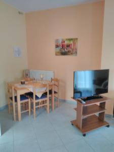 a dining room with a table and a television at Stavroula in Melissátika