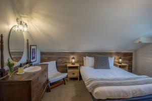 a bedroom with a bed and a sink and a mirror at Purple Mountain Bed & Breakfast & Spa in Crested Butte