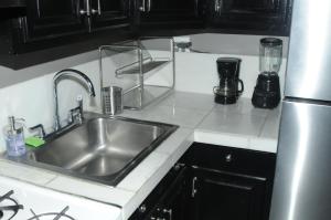 a kitchen counter with a sink and a refrigerator at Plush Spacious 1 bedroom apt Williamsburg in Brooklyn