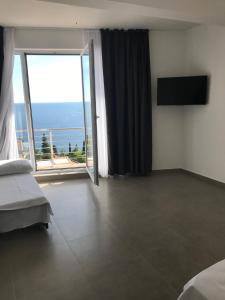 ein Schlafzimmer mit großem Fenster mit Blick auf das Meer in der Unterkunft Villa Grand in Bar
