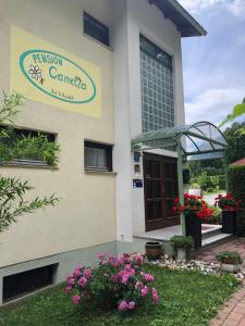 znak na ścianie budynku z kwiatami w obiekcie Haus Camelia w mieście Bad Tatzmannsdorf