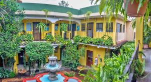 - une vue extérieure sur un bâtiment jaune avec une fontaine dans l'établissement Posada San Vicente by AHS, à Antigua Guatemala