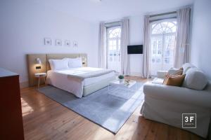 um grande quarto branco com uma cama e um sofá em Calacatta Housing no Porto