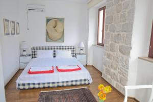 a bedroom with a bed with two red pillows on it at Luxury Waterfront Villa with Private Pool and Private Beach for 12 People in Kotor +47 photos