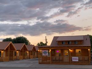 a row of wooden cabins with signs on them at Countryside Cabins in Panguitch