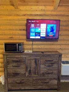 una TV in cima a un mobile in legno con forno a microonde di Countryside Cabins a Panguitch