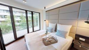 ein Schlafzimmer mit einem weißen Bett und einem Korb darauf in der Unterkunft White Pearl Apartment 1.16 in Timmendorfer Strand