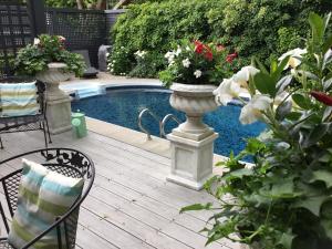 patio z dwoma wazami wypełnionymi kwiatami przy basenie w obiekcie Stone Garden Inn w mieście Trenton