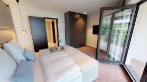 ein Schlafzimmer mit einem weißen Bett und einem großen Fenster in der Unterkunft White Pearl Apartment 1.16 in Timmendorfer Strand