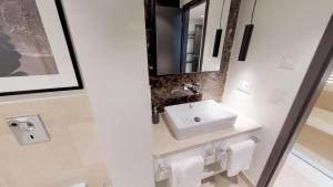 ein Badezimmer mit Waschbecken und Spiegel in der Unterkunft White Pearl Apartment 1.16 in Timmendorfer Strand