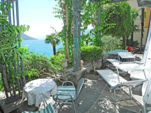 een patio met tafels en stoelen en de oceaan bij Villa Gina App 6060 in Brissago