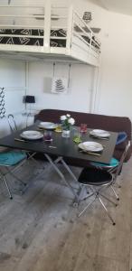 une table noire avec des chaises et des assiettes dessus dans l'établissement studio 2, à Saint-Martin-la-Plaine