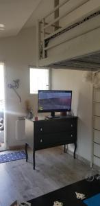 - un salon avec une commode et une télévision à écran plat dans l'établissement studio 2, à Saint-Martin-la-Plaine