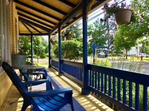 a porch with two blue chairs and a table at Au Saut Du Lit in Magog-Orford