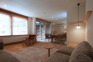 a living room with a couch and a table at Shimogoryo House in Furano