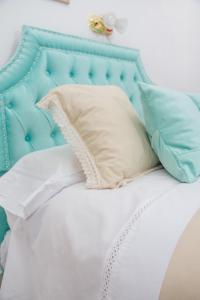 1 cama con cabecero azul y almohadas en Desayuno en Tiffany's en Arroyo Seco