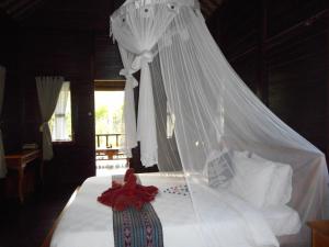 a bedroom with a white bed with a canopy at Kubu Alas Tunggal Villa in Sidemen