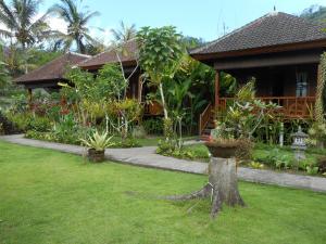 une maison avec une cour ornée de plantes dans l'établissement Kubu Alas Tunggal Villa, à Sidemen