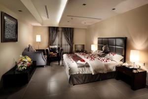 a large bedroom with a large bed and a chair at Towlan Hotel Suites in Al Khobar