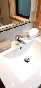 a bathroom sink with a faucet and two cups on it at Fitzherbert Castle Motel in Palmerston North +19 photos