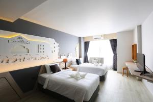 Habitación de hotel con 2 camas y TV de pantalla plana. en Hatyai Signature Hotel en Hat Yai
