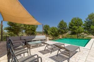 a patio with a couch and chairs next to a swimming pool at Sant Joan Mallorca - 290496 in Sant Joan