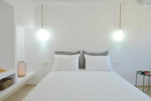 um quarto branco com uma cama branca com almofadas brancas em La casa de Zag em Adamas