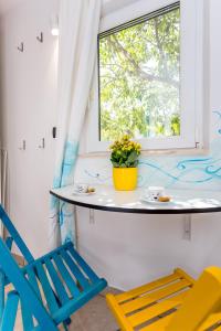 stół i krzesła w pokoju z oknem w obiekcie MiMa's Rooms w Omišu