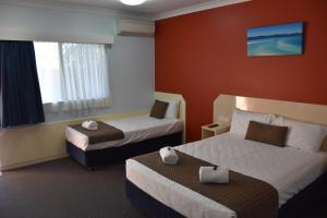 鮑恩的住宿－藍水海港汽車旅館，酒店客房设有两张床和窗户。