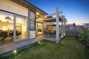 a home with a deck with a dining table at Bonnie's at Barwon in Barwon Heads