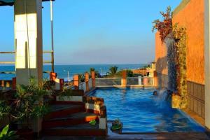 a swimming pool with the ocean in the background at Hotel La Barca in Atacames