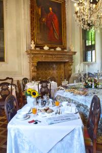 een eetkamer met een witte tafel en een open haard bij Palazzetto Pisani Grand Canal in Venetië