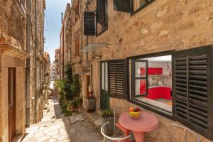 ein kleiner Tisch auf einer Gasse mit einem Fenster in der Unterkunft Apartment Potkova in Dubrovnik