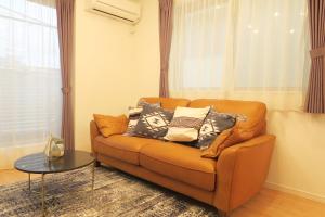 uma sala de estar com um sofá com almofadas em Etranger Kaname Cho em Tóquio