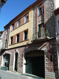 un grand bâtiment en briques avec un grand garage dans l'établissement Maison Baxter, à Prats-de-Mollo-la-Preste