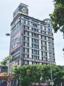 um edifício alto com um sinal em cima em Merryday Hotel Banqiao em Taipei