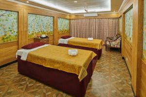 a hotel room with two beds and a chair at MAYFAIR Himalayan Spa Resort in Kalimpong