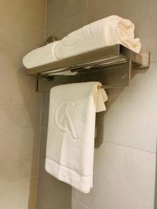 a bathroom with a white towel on a towel rack at City Avenue Hotel in Dubai