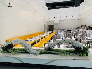 a banquet hall with tables and chairs with flowers at City Avenue Hotel in Dubai